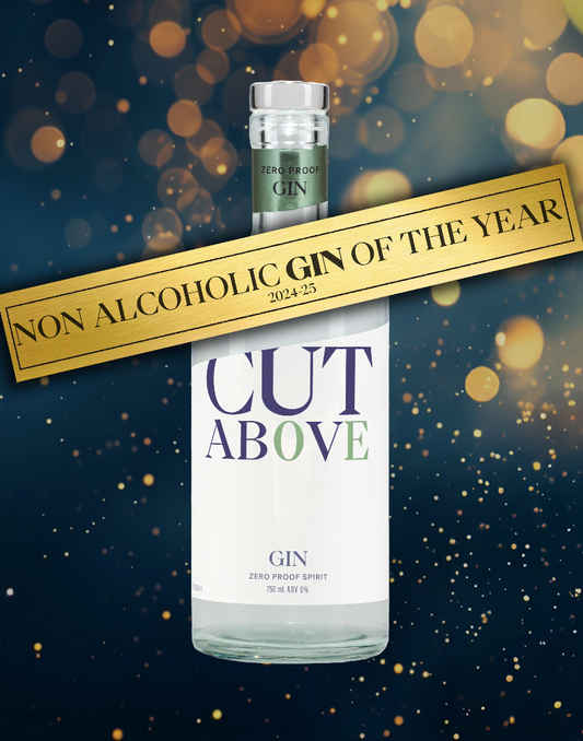 A bottle of Cut Above Zero Proof Gin with a label that reads 'Non Alcoholic Gin of the Year 2021'. The background is dark with bokeh lights.