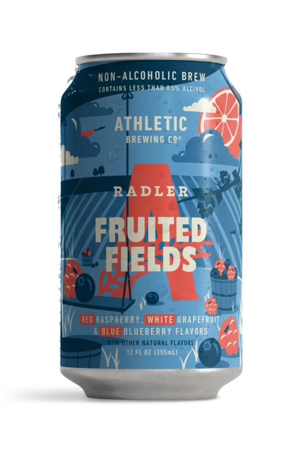 A 12 fl oz can of Athletic Brewing Co. Radler Fruited Fields non-alcoholic brew, featuring a blue label with red, orange, and white illustrations of raspberries, grapes, clouds, and a large red 'A'.