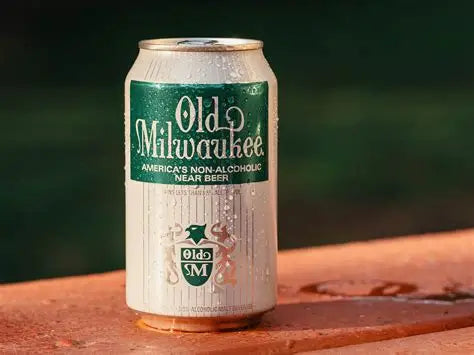 Can of Old Milwaukee non-alcoholic beer on a wooden surface with a blurred green background