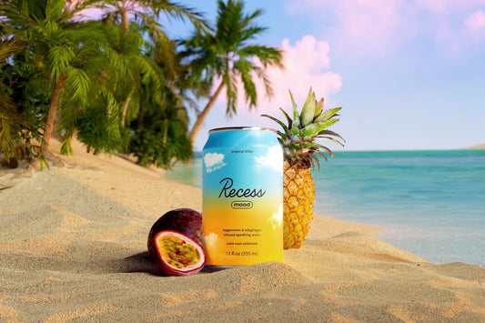 Can of Recess mood with a pineapple and passion fruit on a beach