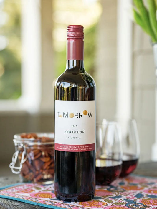 Bottle of Tomorow Red Blend wine on a table with glasses and snacks.