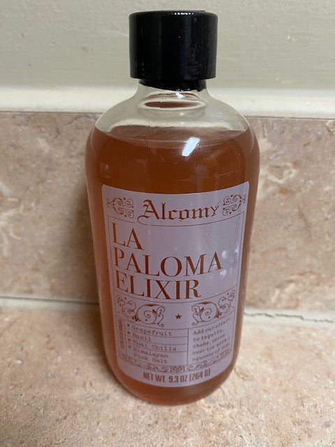 Bottle of La Paloma Elixir on a tiled floor