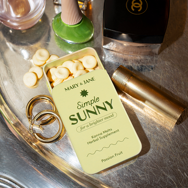 Herbal supplement container labeled 'Simple Sunny' on a reflective surface with accessories.