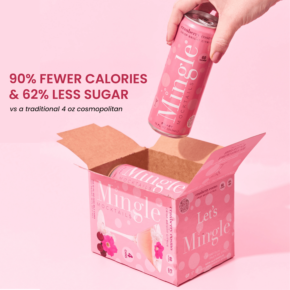 A person holding a can of Mingle Cranberry Cosmo with a box of the product in the background. The can is pink with text and the box has matching pink colors and floral designs.