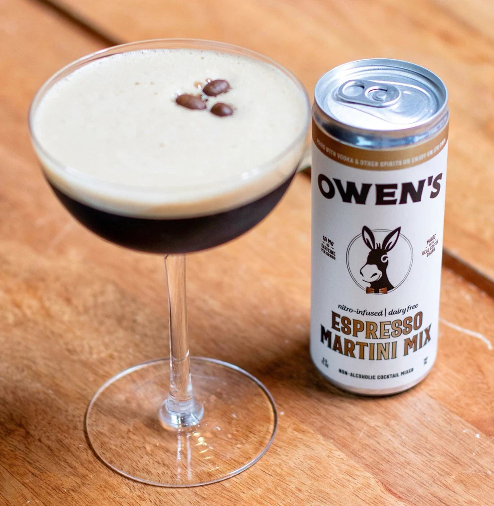 Glass of Espresso Martini with a can of Owen's Espresso Martini Mix on a wooden surface
