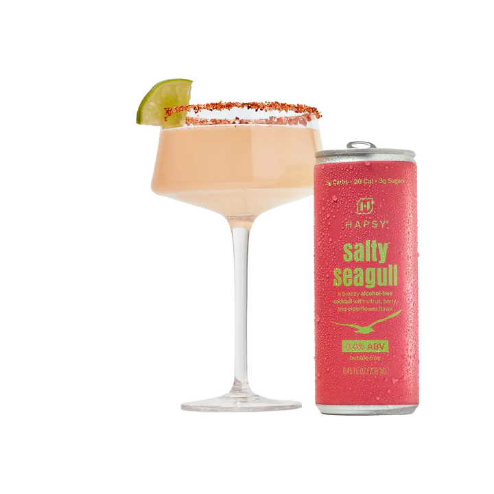Cocktail with a lime wedge and a can of 'Salty Seagull' cocktail mix on a white background