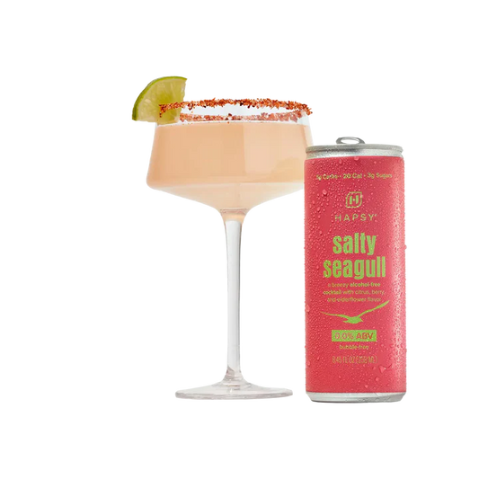 Cocktail with a lime wedge and a can of 'Salty Seagull' cocktail mix on a white background