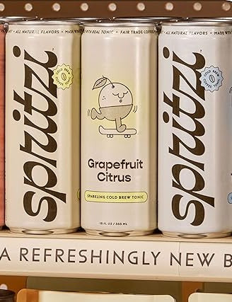 Three cans of Spritztá with 'Grapefruit Citrus' flavor on a shelf.