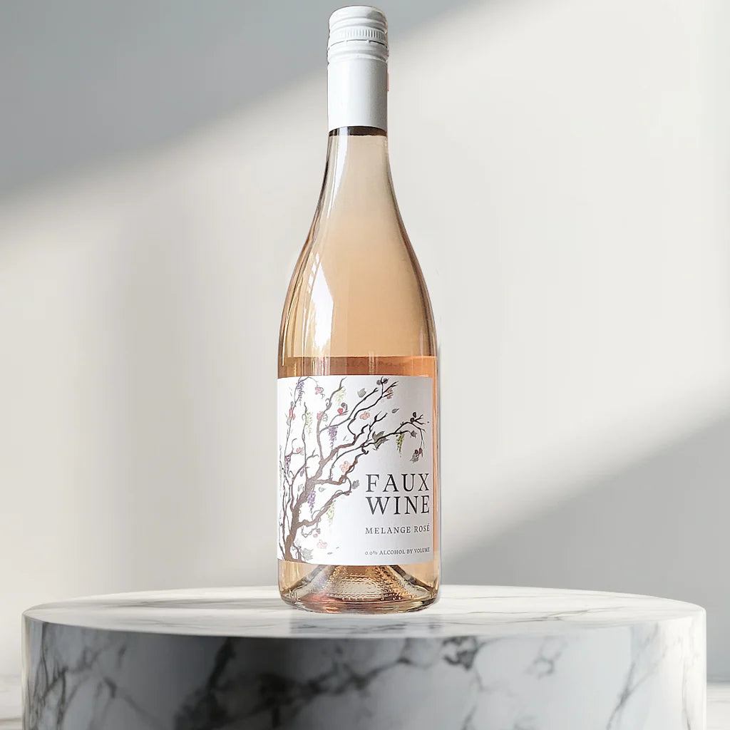 Bottle of 'FAUX WINE' on a marble surface with a light gray background